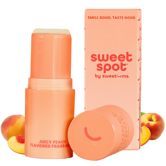 Peach-flavored fragrance stick with packaging and peaches on a white background