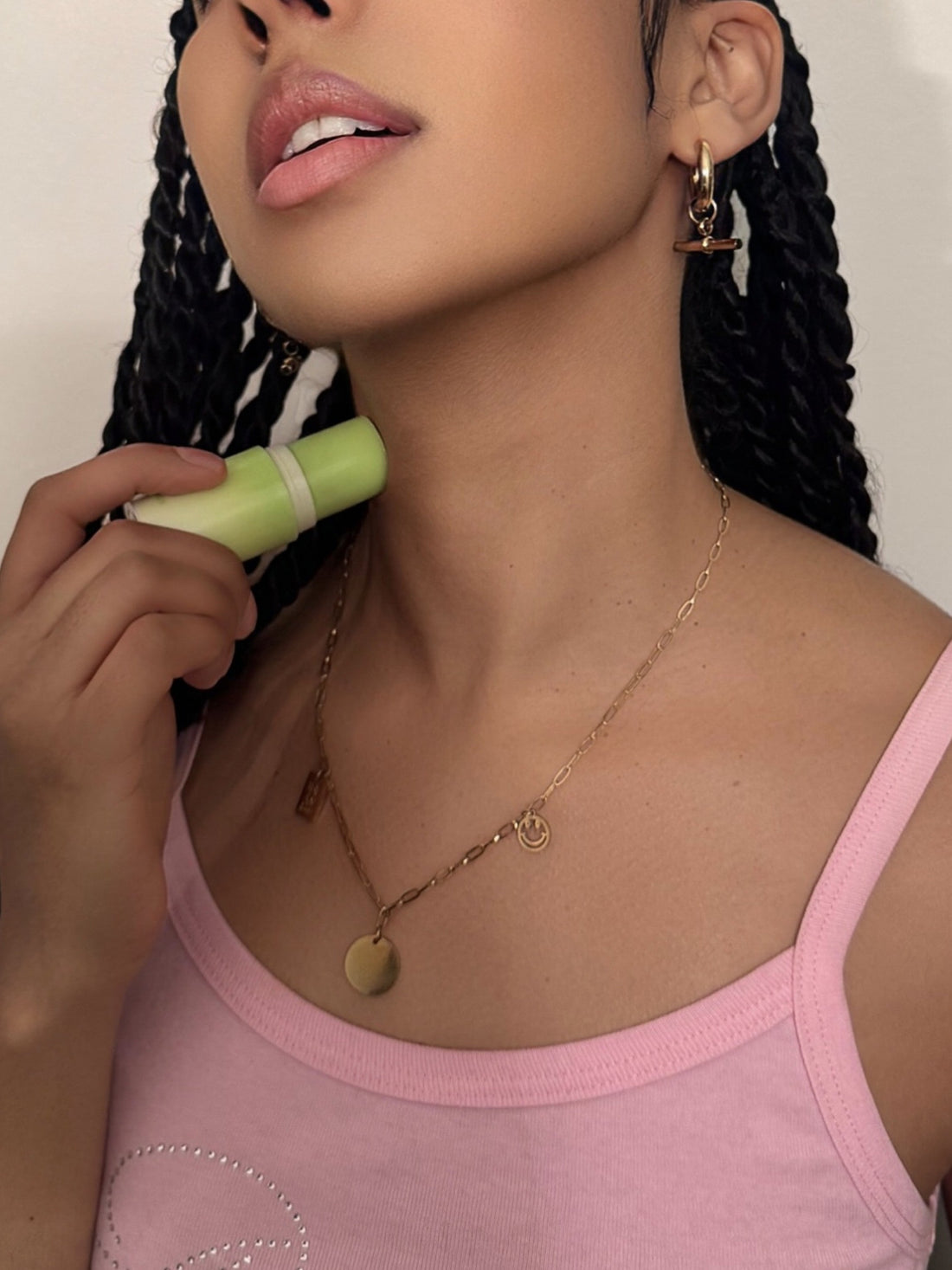 A woman applying sweet spot watermelon flavored fragrance on her neck