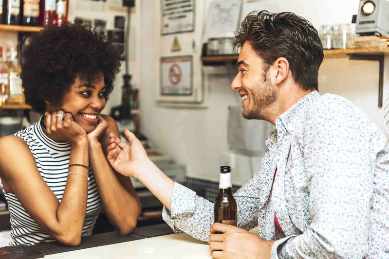 A man sitting with a woman and smiling and flirting