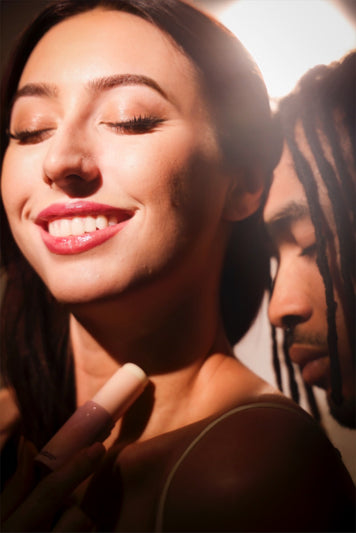 woman applying sweet spot fragrance on her neck with a man smelling her