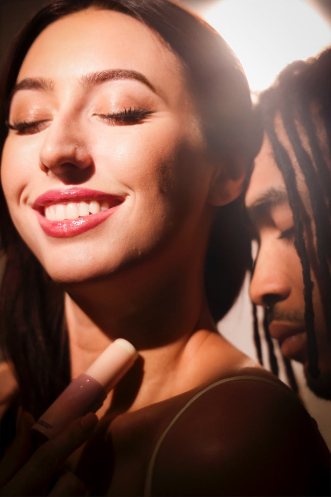 woman applying sweet spot fragrance on her neck with a man smelling her