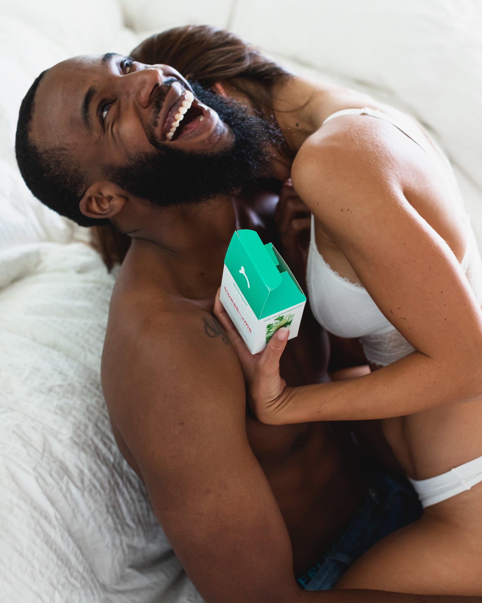 woman and man laughing together while the woman holds sweetums wipes