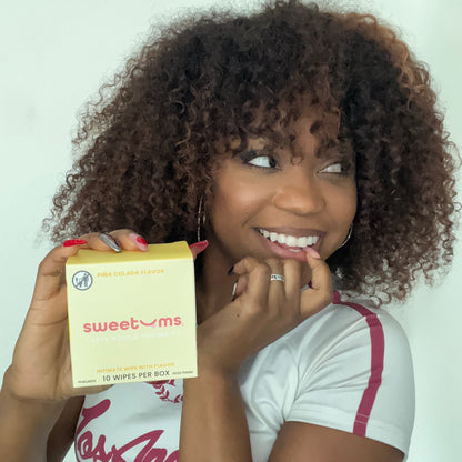 Woman holding a box of 'sweetums' products against a white background