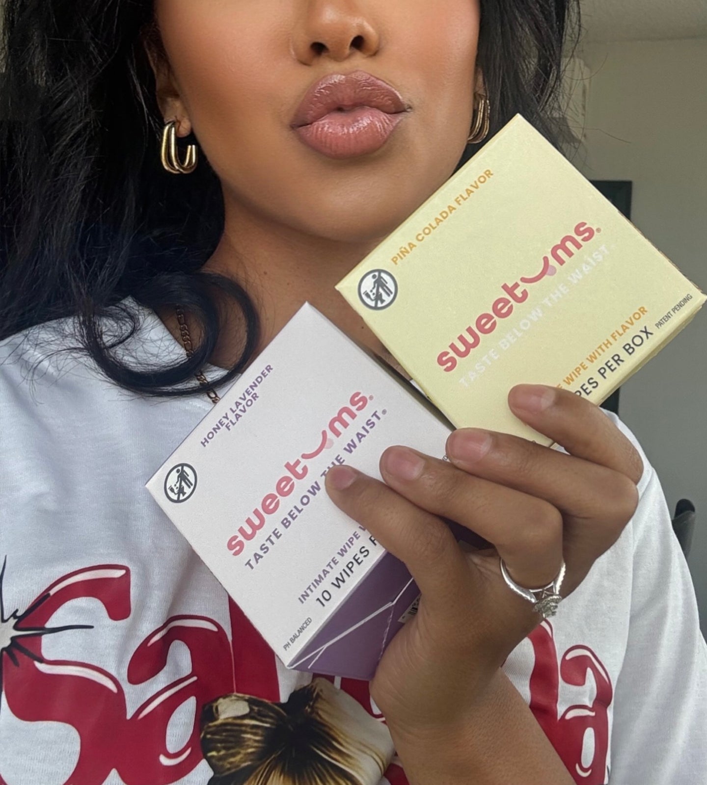 Person holding two boxes of sweetums flavored intimate wipes products