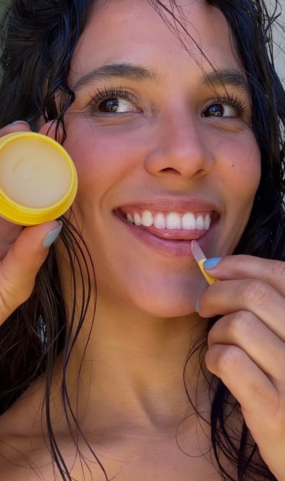 woman applying lip balm to her lips with a plastic applicator