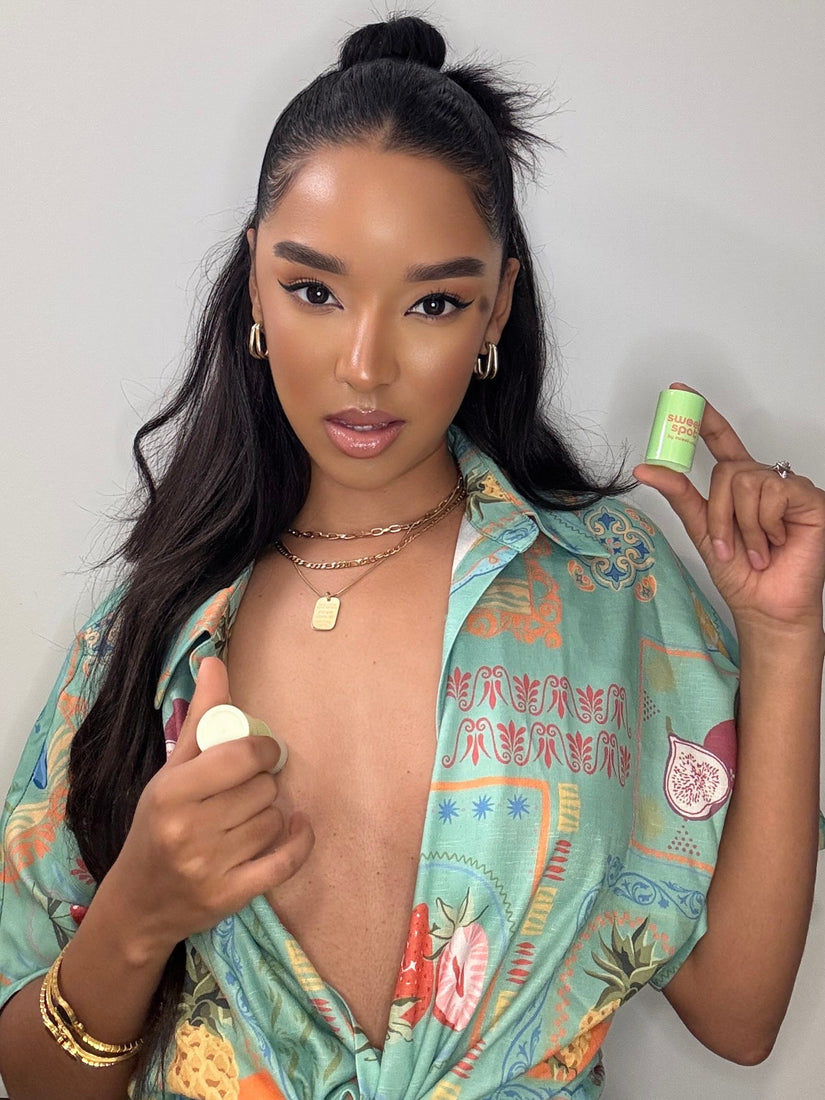 Woman holding a sweet spot solid fragrance against a plain background