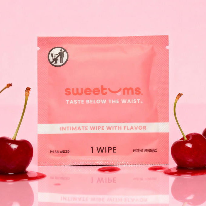 Cherry sweetums wipe on a pink background with cherries next to it.