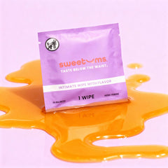 Purple package of 'sweetums' honey lavender flavored intimate wipes with orange liquid on a pink background
