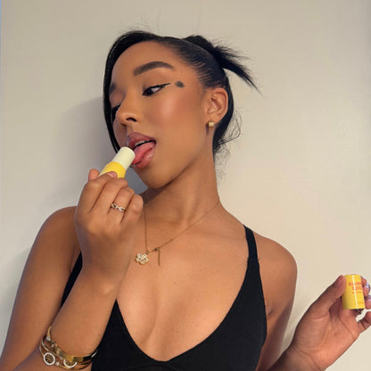 Woman applying Mango Hibiscus Sweet Spot fragrance against a plain background