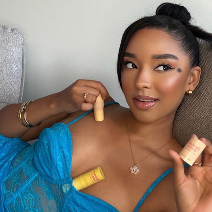 Woman holding a stick of flavored fragrance with a suggestive look on her face