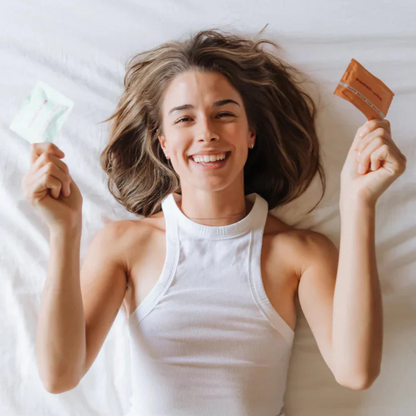 a happy woman holding sweetums flavored intimate wipes