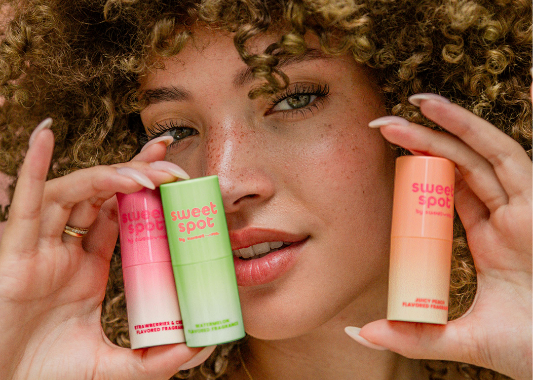Woman holding three sweet spot stick fragrances with scent and flavor