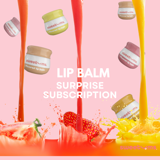 Lip balm surprise subscription with colorful lip balms and a strawberry on a pink background.