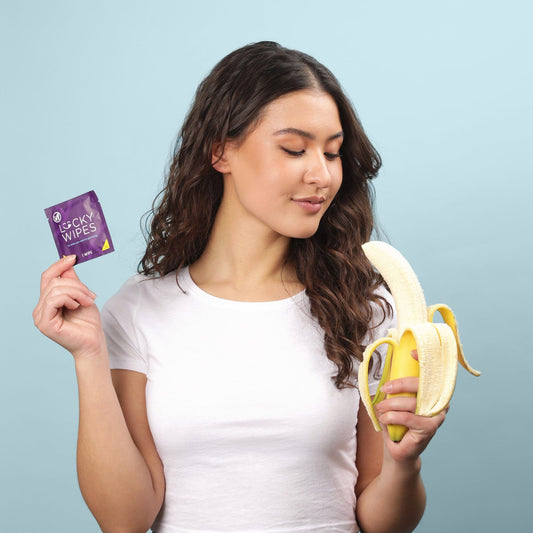 a woman holding a lucky wipe and looking at a banana