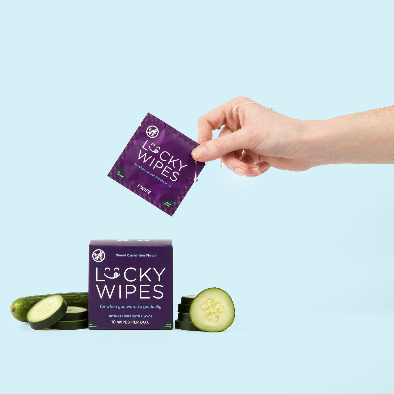 woman holding a lucky wipe and pulling it out of a box of cucumber flavored lucky wipes