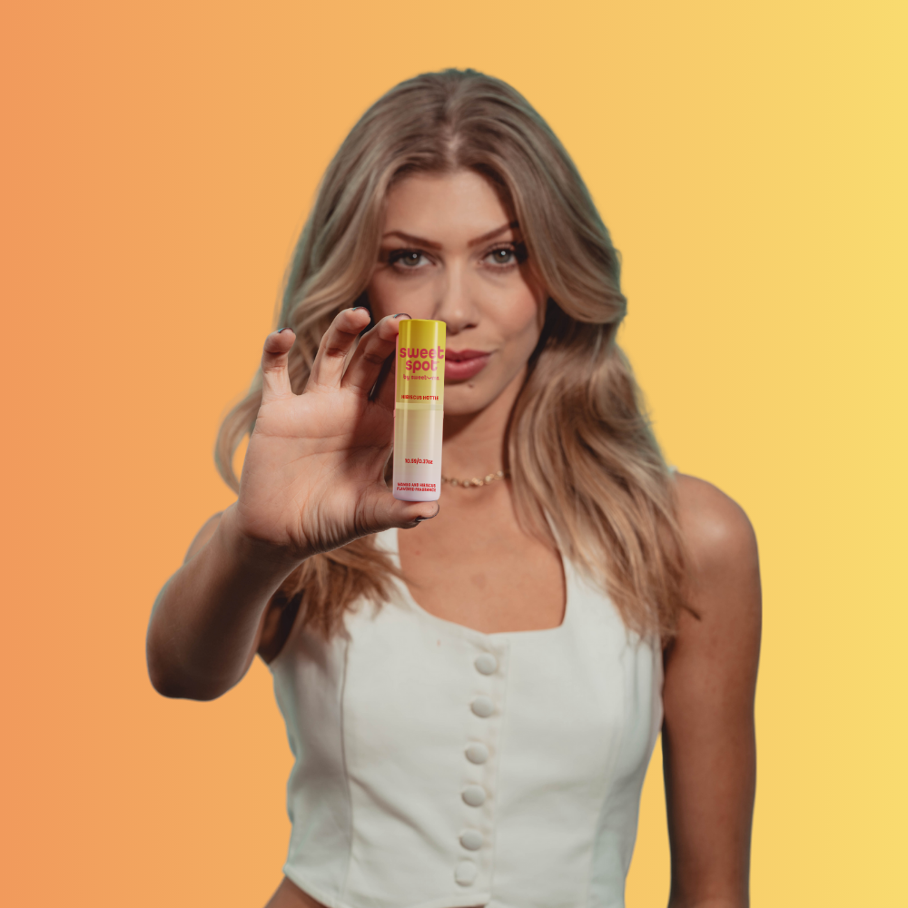 woman holding Hibiscus Hottie Sweet Spot Mango and Hibiscus flavored fragrance