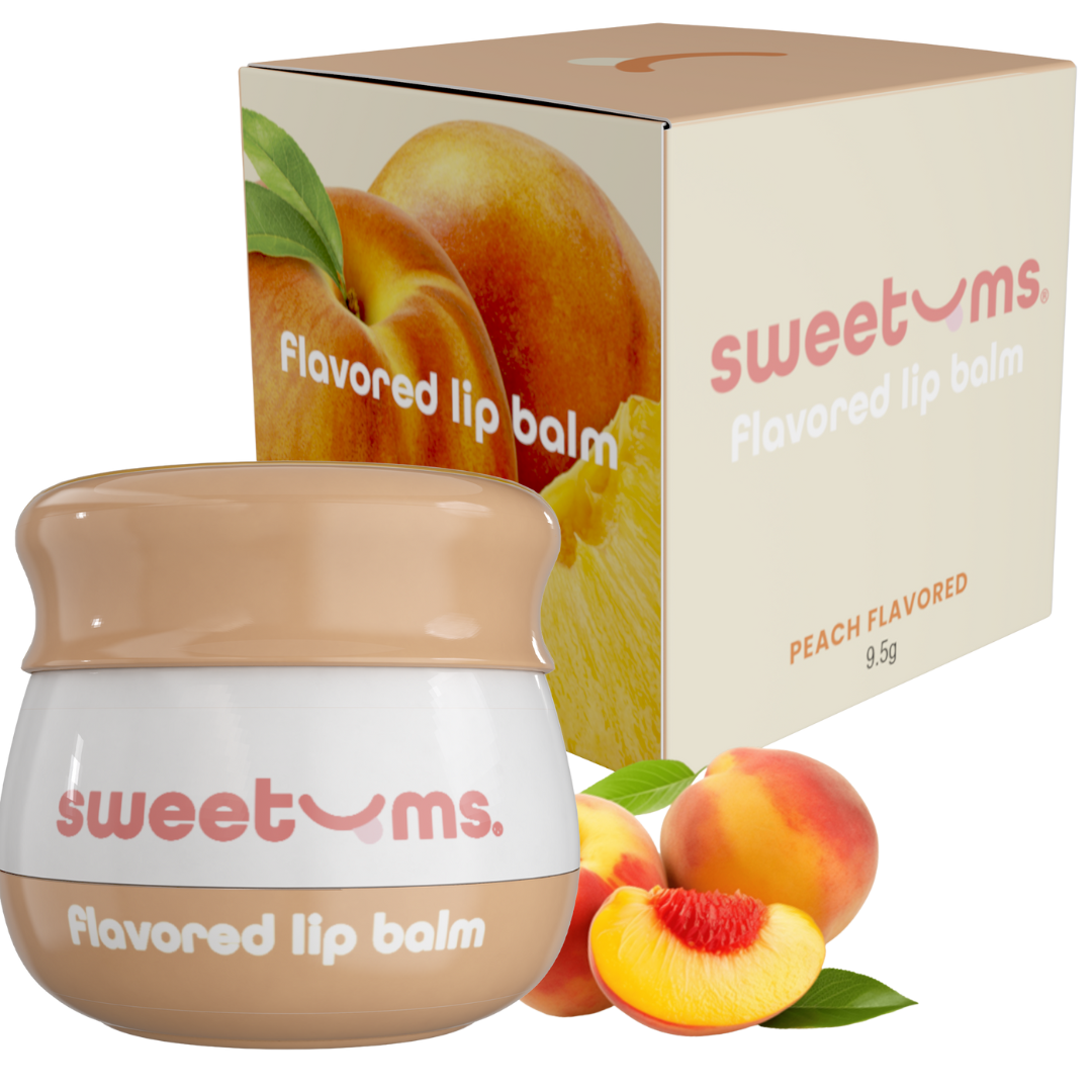 Sweetums peach-flavored lip balm with packaging and peaches on a white background